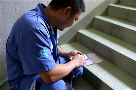 客戶還是沒有到，家具安裝謝師傅蹲在門口等，一邊等一邊處理今天要去的下一家客戶的資料