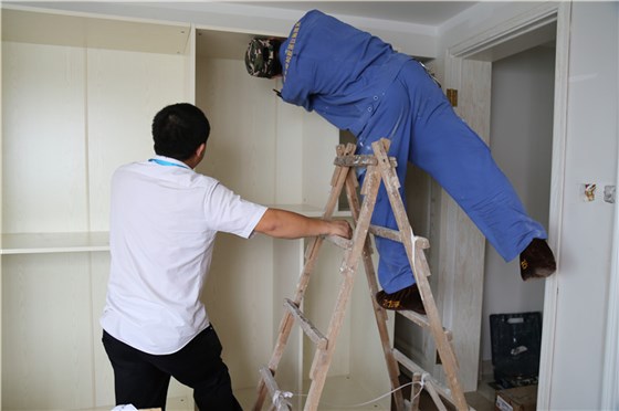 左右手家具安裝師傅彼此合作，完成家具安裝工作