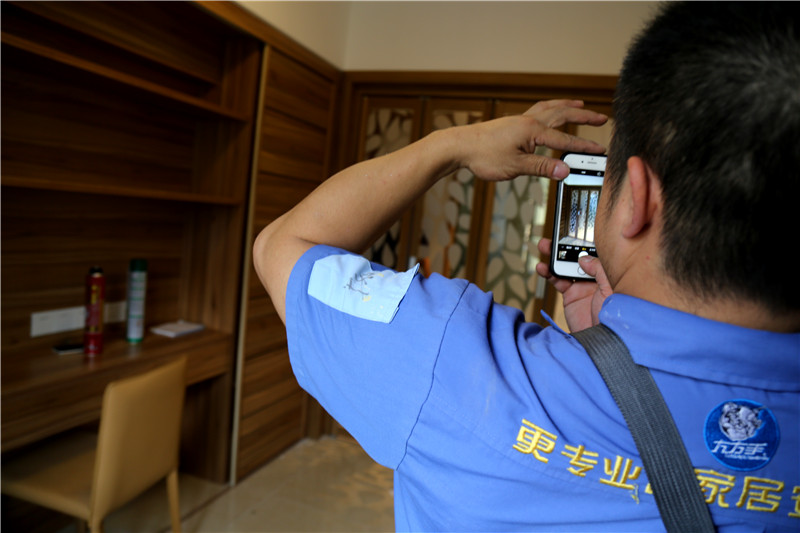 謝師傅看著安裝好的家具，拍下照片